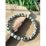 Bracelet pierre dalmatienne 6 mm sur bois avec feuillage vert, perles crème et beige clair tachetées de noir pour spontanéité, ancrage doux et confiance tranquille
