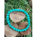 bracelet turquoise stabilisée en perles rondes posée sur champignons en bois  et herbes vertes talisman de protection en voyage et au quotidien