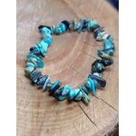 Bracelet turquoise baroque sur élastique posé en cercle sur planche de bois brut, communication apaisée, harmonie relationnelle et protection en déplacement