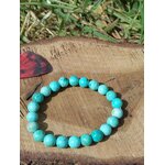 Bracelet turquoise du Pérou sur bois avec herbe en fond, nuances lagon 8 mm pour expression sereine, écoute posée et paix intérieure