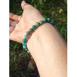 Bracelet turquoise du Tibet porté au poignet en lumière naturelle, perles bleu-vert mates, ancrage apaisé et parole fluide