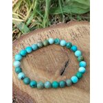 Bracelet turquoise du Tibet sur rondin de bois brut, perles rondes aux tons aqua et vert forêt, recentrage et harmonie intérieure