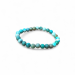 Bracelet turquoise du Tibet sur fond blanc, perles rondes bleu lagon et vert minéral, bijou en pierre naturelle pour confiance et protection.