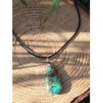 Collier sur cordon noir avec pendentif turquoise africaine goutte bleu-vert posé sur rondelle de bois en décor nature, jaspe africain relié à l’ancrage doux, à la stabilité et à l’expression sincère.