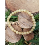 Bracelet calcite jaune porté au poignet, perles rondes aux reflets dorés, dynamisme doux, assurance et rayonnement personnel