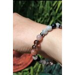 Bracelet Deuil porté au poignet sur fond de feuillage vert, soutien émotionnel, présence rassurante et apaisement du ressenti