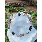 Bracelet Deuil photographié sur amas de quartz avec feuillage vert, bijou en pierre naturelle pour accompagner les transitions et soutenir l’équilibre émotionnel