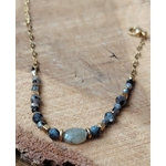 Bijou labradorite suspendu sur fond bois beige, bracelet acier inoxydable doré au style lumineux, stabilité émotionnelle et recul