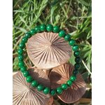 Bracelet jade africain 6 mm sur champignons en bois dans l’herbe, perles vert profond et vert mousse pour sérénité et recentrage du mental