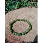 Bracelet jade néphrite 6 mm sur rondin au fond boisé clair, perles vert olive, vert céladon et marbrures naturelles pour lâcher-prise et force calme