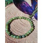 Bracelet jade du Canada 6 mm sur rondin de bois avec papillon bleu en arrière-plan, perles vert marbré et vert forêt pour ancrage léger et recentrage