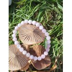 Bracelet kunzite 6 mm sur champignons en bois et herbe verte, perles rose lilas et nuances translucides, bienveillance, lâcher-prise et respiration intérieure
