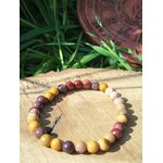 Bracelet mookaïte 6 mm sur planche en bois avec feuillage vert et disque gravé, perles ocre, crème, bordeaux et prune pour stabilité, élan vital et assurance sereine
