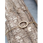 Bracelet chaîne ovale pavé de strass en acier inoxydable doré, photographié en Bretagne, posé sur une grosse écorce claire à motifs, fond bleu flou, lumière naturelle.