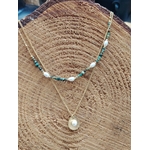 Collier double chaîne dorée acier inoxydable, perles blanches, pierres vertes, médaillon nacré, sur tranche de bois.
