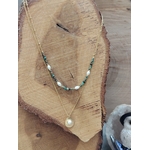 Collier double chaîne dorée acier inoxydable, perles blanches, pierres vertes, médaillon nacré, présenté sur buste en bois.