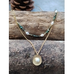 Collier double chaîne dorée acier inoxydable, perles blanches, pierres vertes, médaillon nacré, sur bois et pierre.