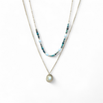 collier double chaîne acier inoxydable doré perles blanche, pierres vertes et médaillon nacré photographié sur fond blanc