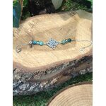 Bracelet symbole antique argenté, amazonite bleu-vert, Aqua Aura irisé, apatite turquoise, posé sur rondin de bois, ambiance nature, sérénité, expression, confiance, équilibre émotionnel