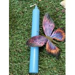 Bougie bleue dans la mousse avec papillon violet-orange; apaisement, sérénité, expression.