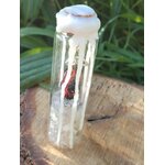 Spell jar en fiole de verre avec cire blanche et éclats de cristal de roche, photo en extérieur sur bois, ambiance protection et purification.