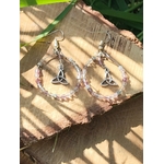 Boucles d’oreilles Hécate en fluorite facettée, création Magic Gaïa, anneaux perlés dégradés et breloques triquetra argentées, posées sur rondin de bois au soleil avec ombres rayées. Clarté, apaisement, intuition