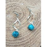 Boucles d’oreilles spirales argentées et perles d’apatite bleue sur bois clair, focus, inspiration, communication.