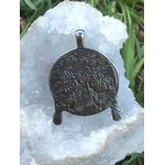 Pendentif viking en métal noirci avec arbre sacré et corbeaux en relief, posé sur géode blanche scintillante et feuillage vert