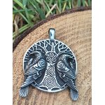Pendentif viking verso argenté noirci avec gravure arbre sacré et spirales, posé devant mousse, feuillage vert et pierre blanche