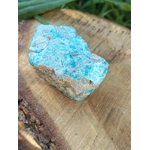 Apatite bleue brute bleu lagon avec matrice claire sur fond blanc, pierre naturelle reliée à la créativité, à l’assurance et à la clarté intérieure.