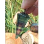Pendule en fluorite facettée tenu en main, décor herbes vertes et tranche de bois gravée, aide au recentrage, à la clarté et à l’intuition.