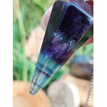 Gros plan sur pendule en fluorite facettée, dégradé violet/vert, décor végétal et bois, aide à la clarté mentale et au recentrage