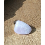 Pierre roulée de kunzite rose très pâle, galet poli de forme triangulaire posé sur rondin de bois clair, pierre naturelle liée à la douceur du cœur, à la tranquillité et au recentrage.