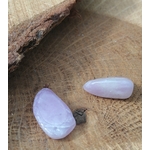 Deux pierres roulées de kunzite rose très pâle aux reflets laiteux, déposées sur support en bois brut, pierres naturelles évoquant le calme intérieur, le lâcher-prise et la douceur affective.