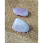 Pierre roulée de kunzite rose pâle à lilas, polie et lisse, posée sur planche en bois, galet naturel relié à la paix émotionnelle, à la délicatesse et à l’harmonie du cœur.