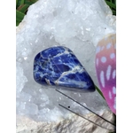 Pierre roulée de sodalite bleu profond veinée de blanc sur amas de quartz avec encens et décor champignon, galet naturel associé à la lucidité, à la paix émotionnelle et à l’écoute de soi.