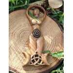 Statuette Gaïa (déesse) en bois style wicca avec spirale et triquetra, posée sur une tranche de bois dans un décor végétal; évoque ancrage, harmonie, protection douce, intuition et énergie féminine, idéale pour autel et déco ésotérique.