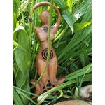 Statuette Gaïa en bois style wicca avec spirale et triquetra, photographiée au cœur des feuilles vertes dans un décor nature; invite à l’ancrage, au calme intérieur, à l’harmonie, à la protection douce et à l’intuition.