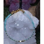 Bracelet amazonite bleu lagon avec intercalaires en cuivre plaqué or, posé sur quartz et pierres naturelles, bijou délicat pour calme intérieur.
