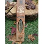 Encens HERBIO Cannelle 25 g en étui kraft avec fenêtre, mis en scène sur herbe et feuilles d’automne avec rondin de bois; note épicée, atmosphère réconfortante et conviviale