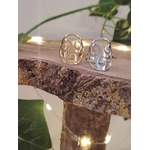 Deux bagues Triskell inox doré et argenté posées sur branche, décor feuillage; symbole cycles et équilibre.