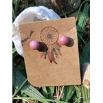 Boucles d’oreilles puces rhodonite rose, tiges acier inoxydable, sur carte kraft attrape-rêves avec géode et feuillage; évoque douceur et apaisement émotionnel.