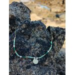 Collier en acier inoxydable doré orné de cristaux verts et petites perles sur rochers près de l’océan, bijou raffiné au charme frais