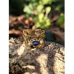 Bague dorée réglable en acier inoxydable, motif feuilles ajourées et pierre ovale lapis-lazuli; photo en Bretagne sur décor naturel.