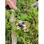 Bague dorée réglable en acier inoxydable, motif feuilles et pierre ovale lapis-lazuli, photo en Bretagne sur mousse et brindilles.