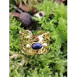 Bague dorée réglable en acier inoxydable, motif feuilles et pierre ovale lapis-lazuli, photo en Bretagne sur mousse.