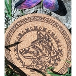 Dessous de plat rond en liège, loup gravé, bordure celtique; photo dans l’herbe, ombres de feuilles. Symbolique: instinct, protection, loyauté