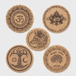 Lot de 5 dessous de plat ronds en liège gravés (Om, œil, loup, arbre de vie soleil/lune, arbre Magic Gaïa) sur fond blanc.