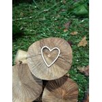 Bracelet chaîne fine en acier inoxydable, pendentif cœur ajouré; posé sur rondins de bois, décor mousse et feuilles en extérieur.