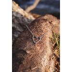 Pendentif cœur ajouré martelé en acier inoxydable argenté sur chaîne fine, posé sur tronc d’arbre avec écorce et mousse, bijou lumineux au style naturel